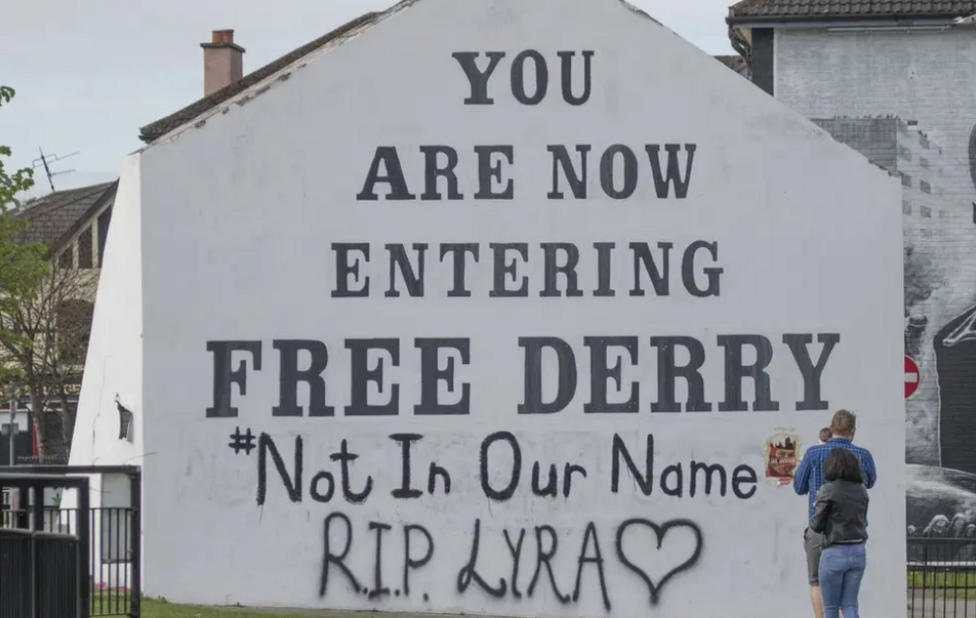 Free Derry Corner, a large white gable wall which reads: 'You are now entering Free Derry #NotInOurName RIP Lyra'