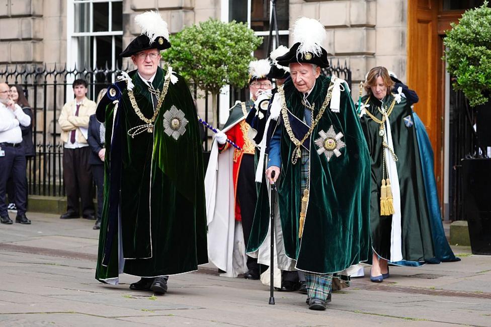 Lord Robertson of Port Ellen and Lord Steel of Aikwood in the green robes of the Order of the Thistle, walk though Parliament Square.