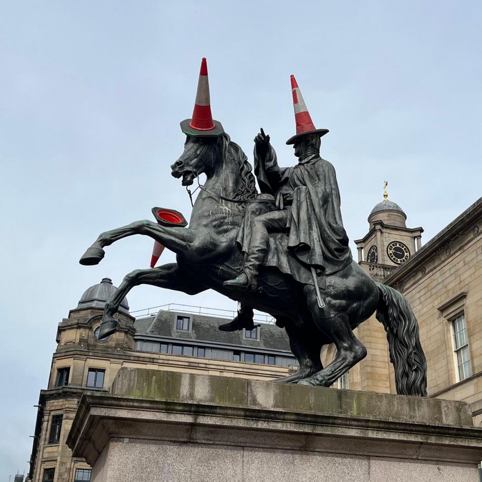 The Duke of Wellington statue in Edinburgh with traffic cones on it.