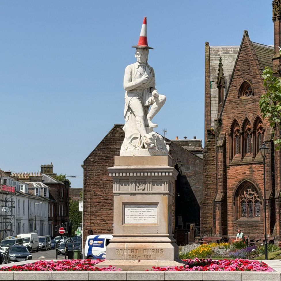 The Robert Burns statue in Dumfries with a cone on its head.