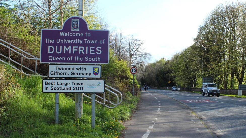 A signpost next to a road saying