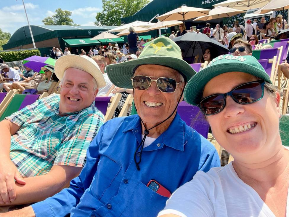 Lucy and her friends Richard and Phil are sitting in deckchairs in the Wimbledon grounds