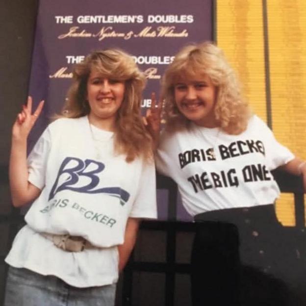 The two women are both in Boris Becker T-shirts and are making peace signs