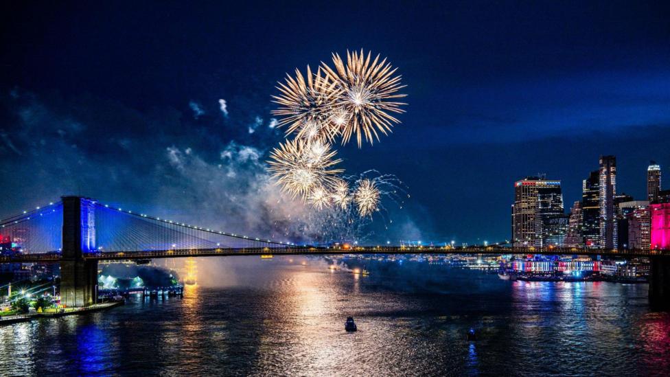 Fireworks light up the sky over the Brooklyn Bridge during a fireworks display marking the 250th anniversary of US independence in New York, New York