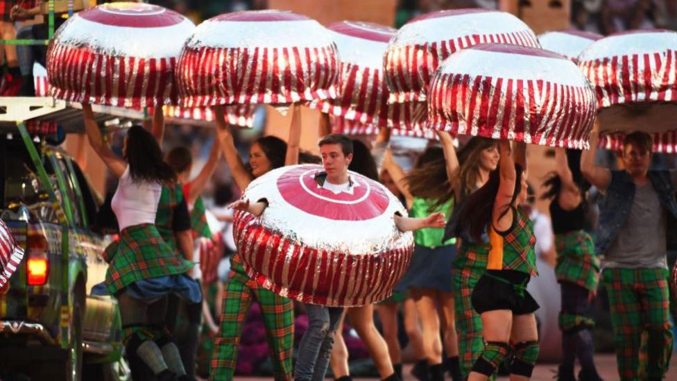 Dancers dressed as tea cakes dance around, during an opening ceremony event for the Commonwealth Games in Glasgow