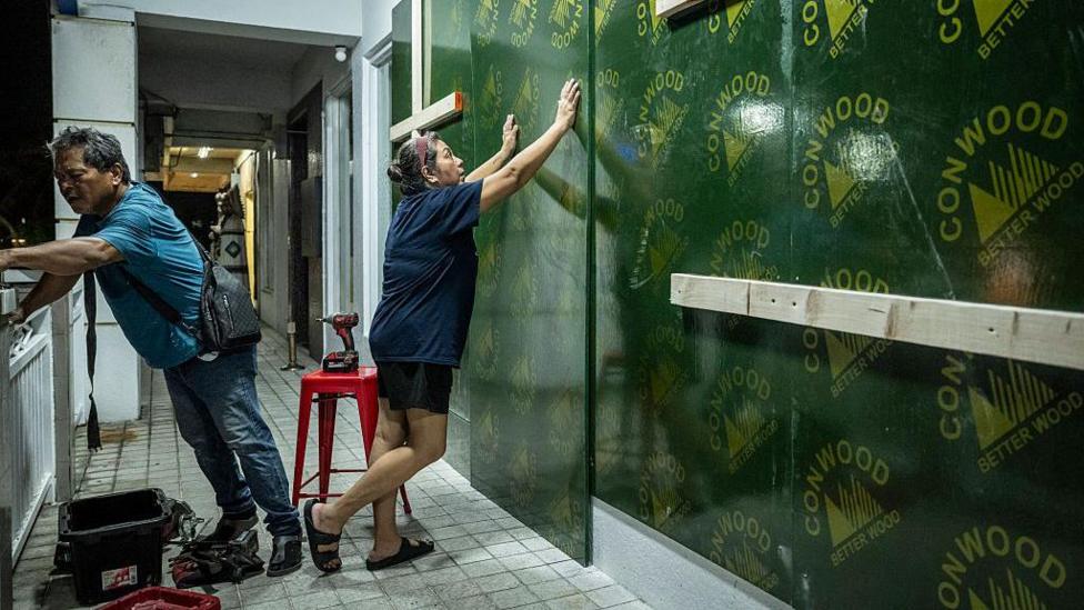 Restaurant workers board up a restaurant ahead of the arrival of the forecasted Super Typhoon Bavi in Guam on July 4, 2026. People in Guam and the Northern Marianas readied themselves on July 4 as the second