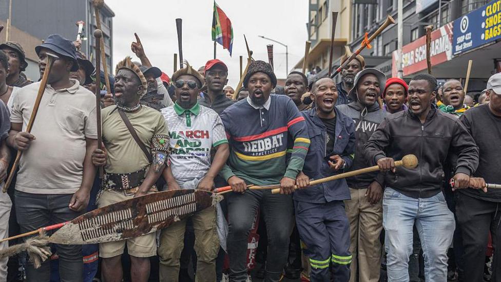 Members of the Zulu regiment known as the 'Amabutho' holding sticks march during a demonstration