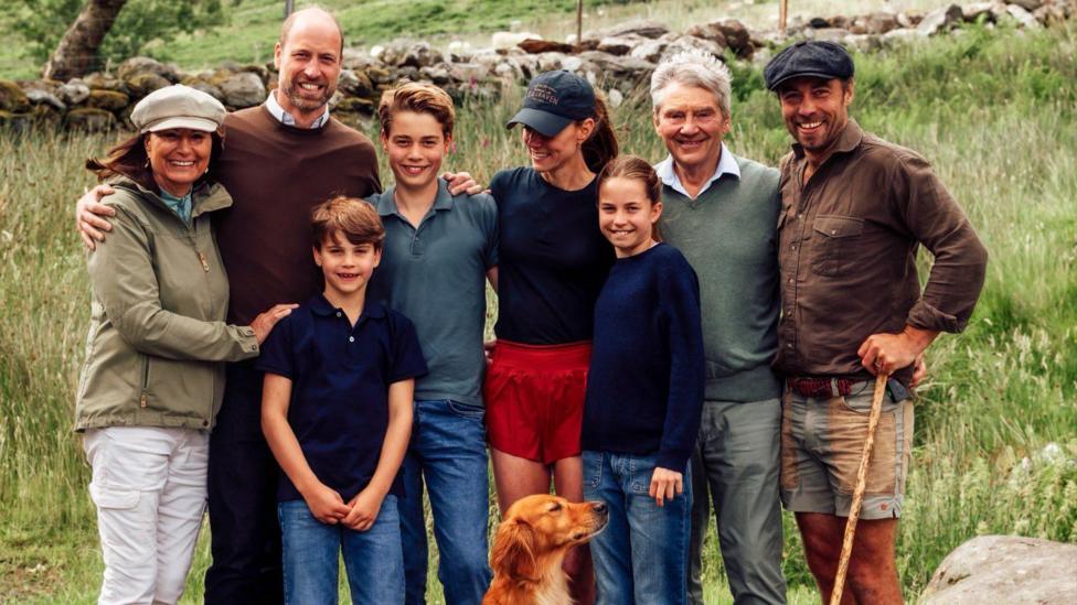 Catherine in the middle, next to her dad and son, husband, mum, brother and two other children. A golden retriever sits at their feet