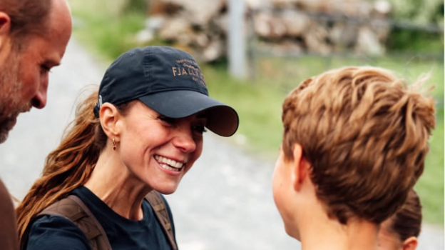 Kate smiles at George who has his back to the camera as William looks on