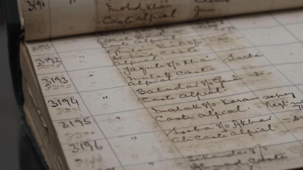 A large book is open, showing a table of handwritten entries of soliders from World War One