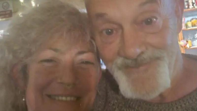 A woman and a man smile for a blurred selfie