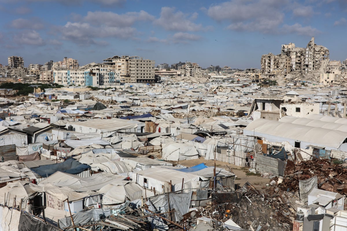 Tents and makeshift shelters housing displaced Palestinians stretch amid the ruins of buildings near the al-Shati refugee camp, Gaza City, on 1 July.