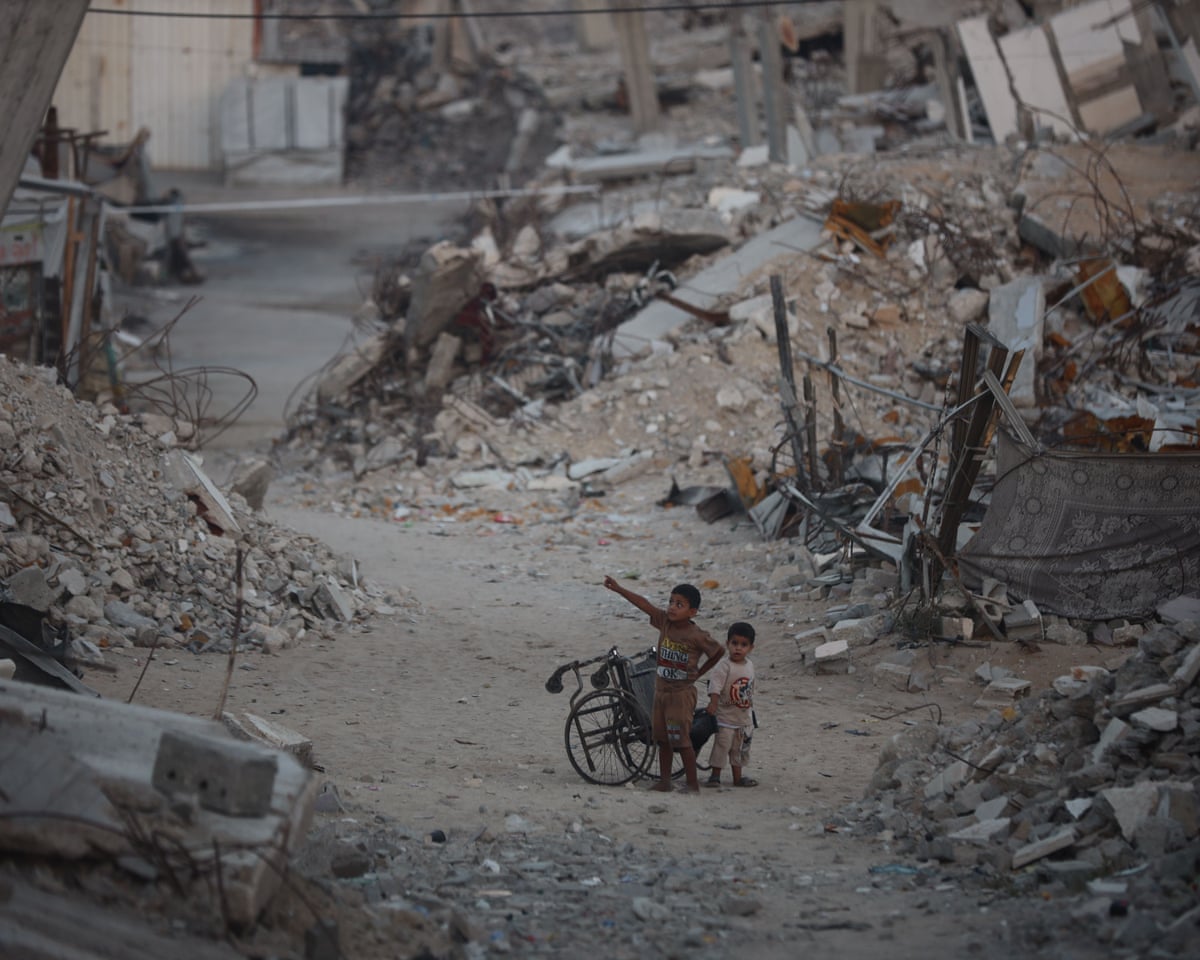 Palestinian children stand among destroyed homes in Gaza City in June.