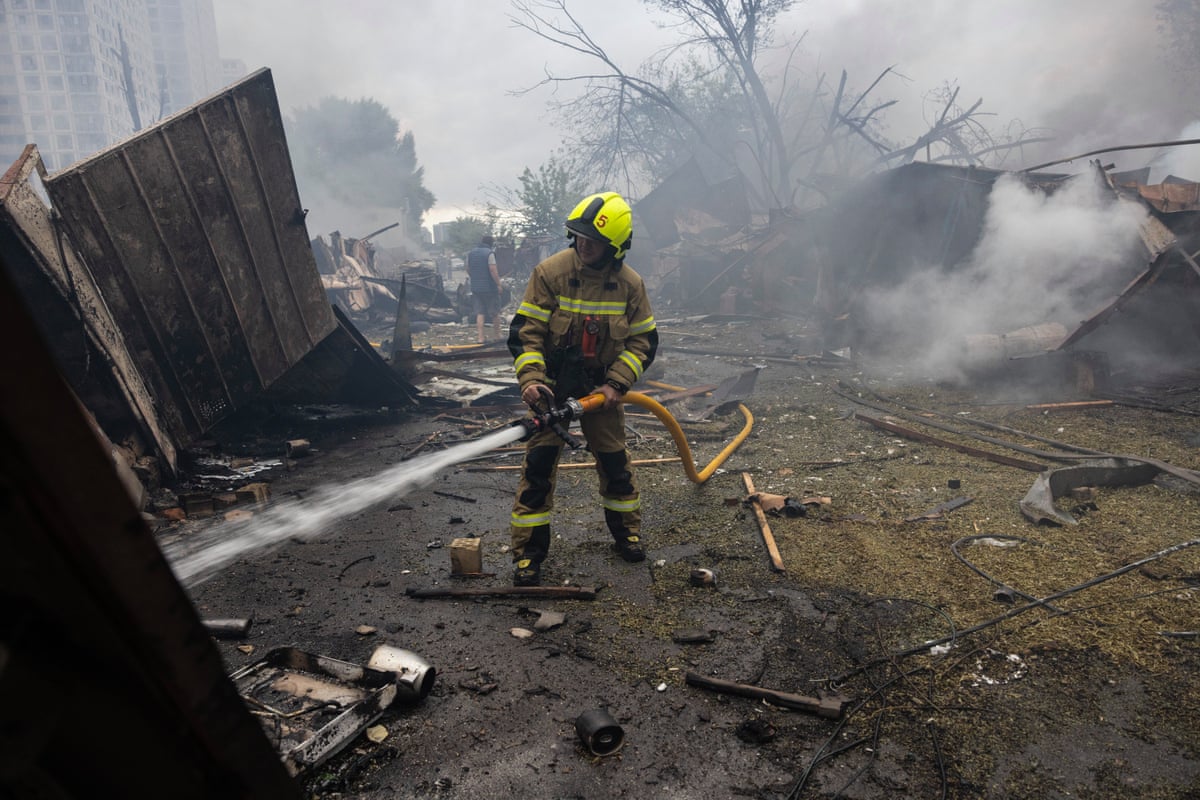 A firefighter tackles a blaze that engulfed a residential building in Kyiv.