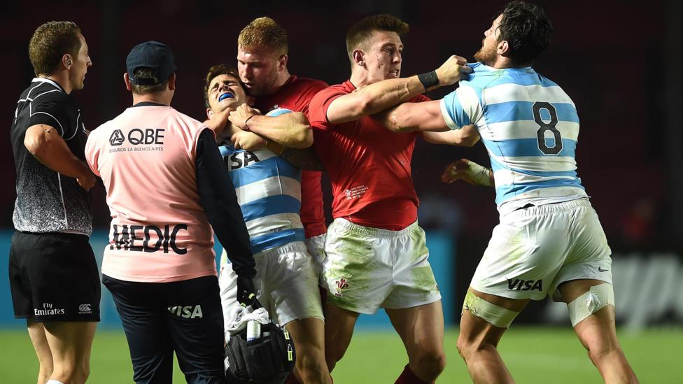 Match officials watch as Ross Moriarty and Josh Adams of Wales grapple with Nicolas Sanchez and Javier Ortega Desio of Argentina