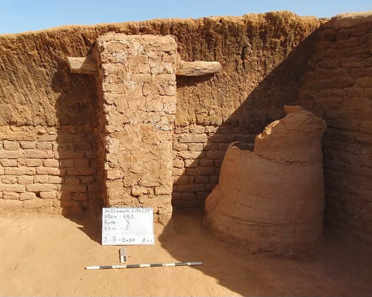 A pillar and bread oven in the corner of a wall in an archaeological site