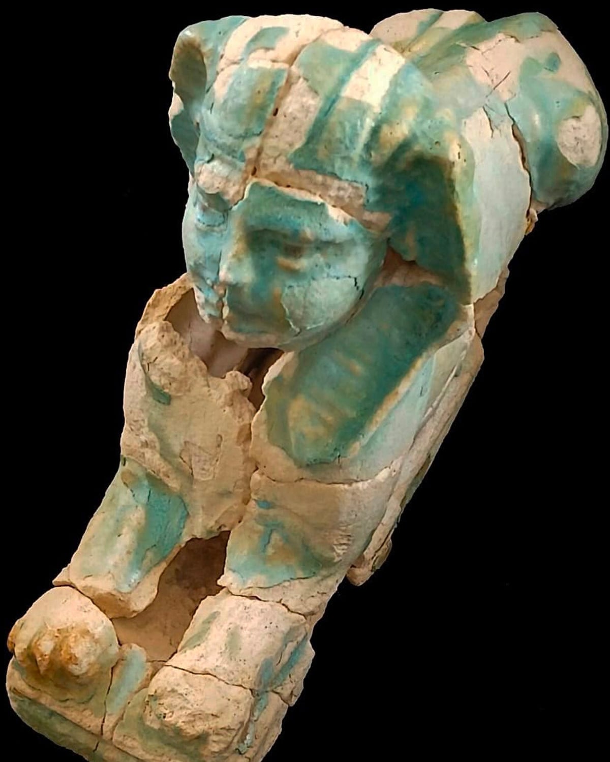 A sphinx-like stone sculpture, partly green in colour