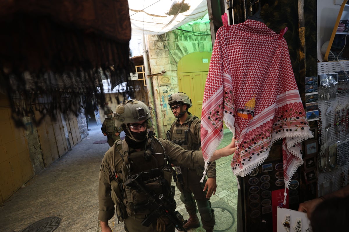 Two military personnel patrolling a market