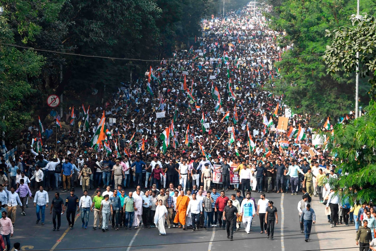 Marchers with Indian flags and political banners fill a wide avenue in Kolkata