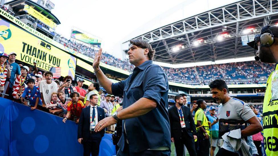 Mauricio Pochettino waves to fans as he leaves the pitch