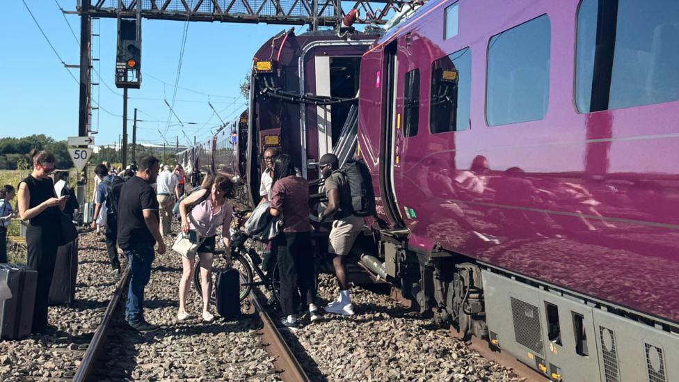 Passengers being evacuated from a crashed train on to the adjacent tracks.