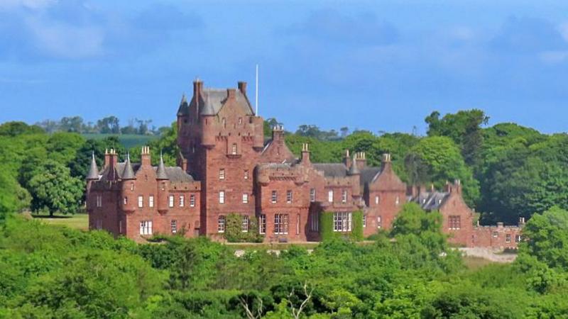 Ayton Castle - an imposing sandstone building with various turrets surrounded by trees