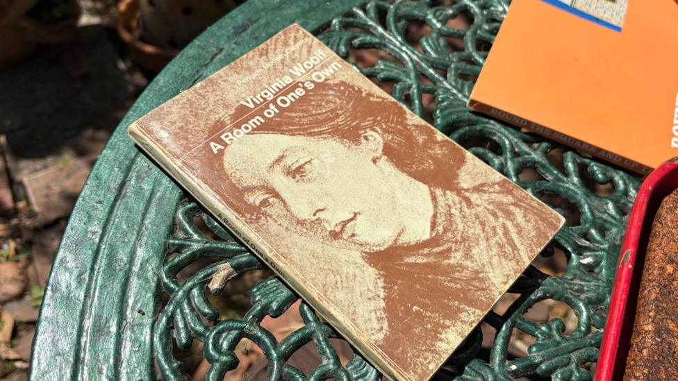 A copy of Virginia Woolf's 1929 book 'A Room of One's Own' placed on a garden table.