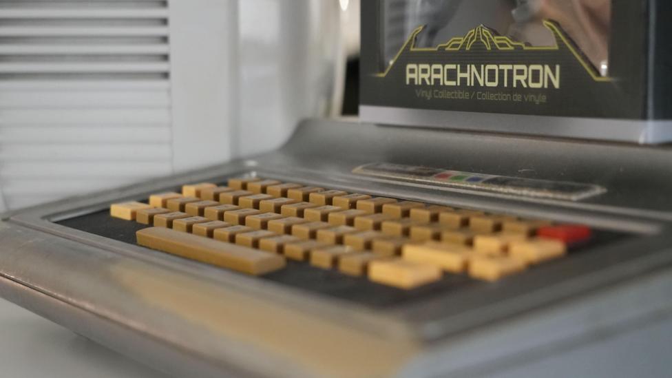 A close up of a retro game. There is writing on the game which says, ARACHNOTRON on it in yellow writing.