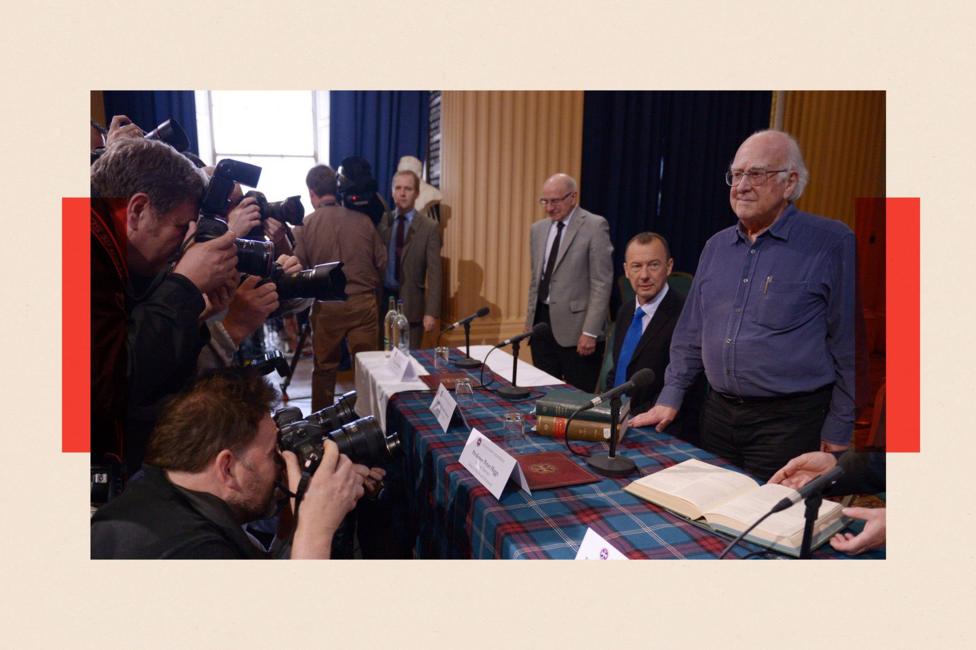 Peter Higgs arrives at a press conference before being awarded the Nobel Prize in Physics
