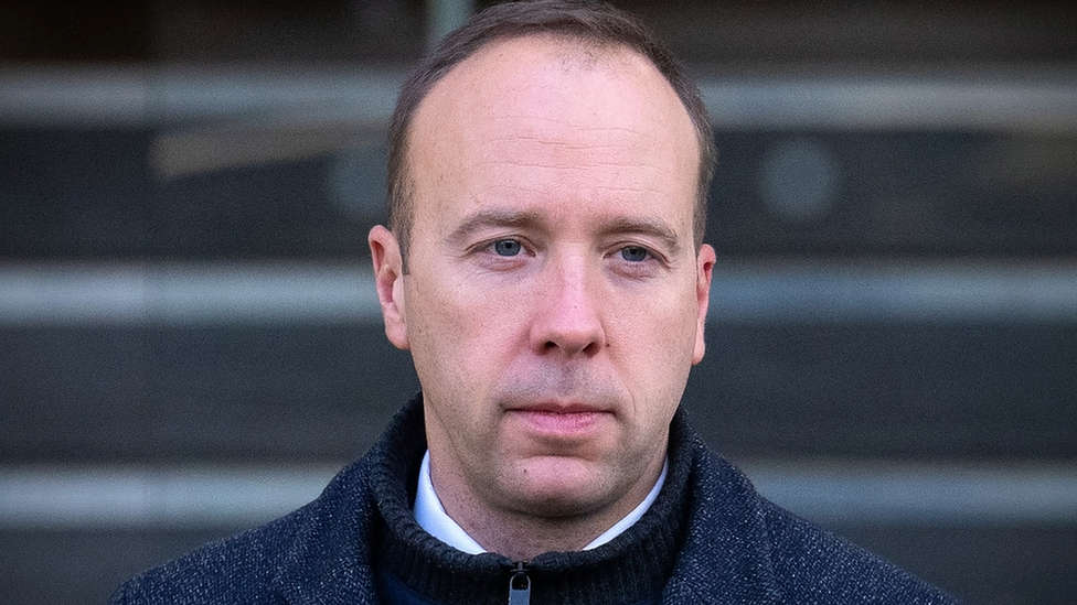 Former Health Secretary Matt Hancock looks pensive as he leaves the Covid Inquiry after giving evidence. He wears a white shirt, black zip up sweater and a grey jacket.