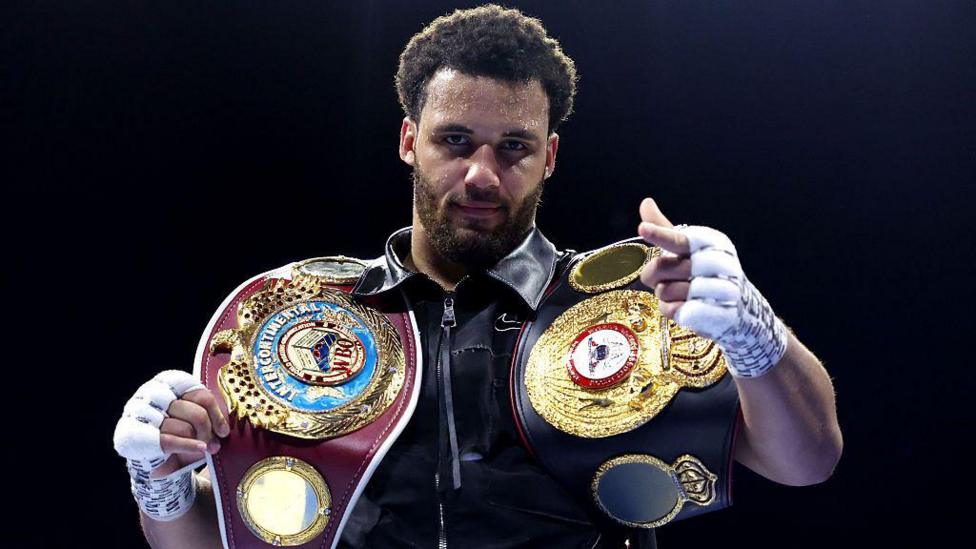 Moses Itauma points his finger and has the WBA International and WBO Inter-Continental heavyweight titles on his shoulders