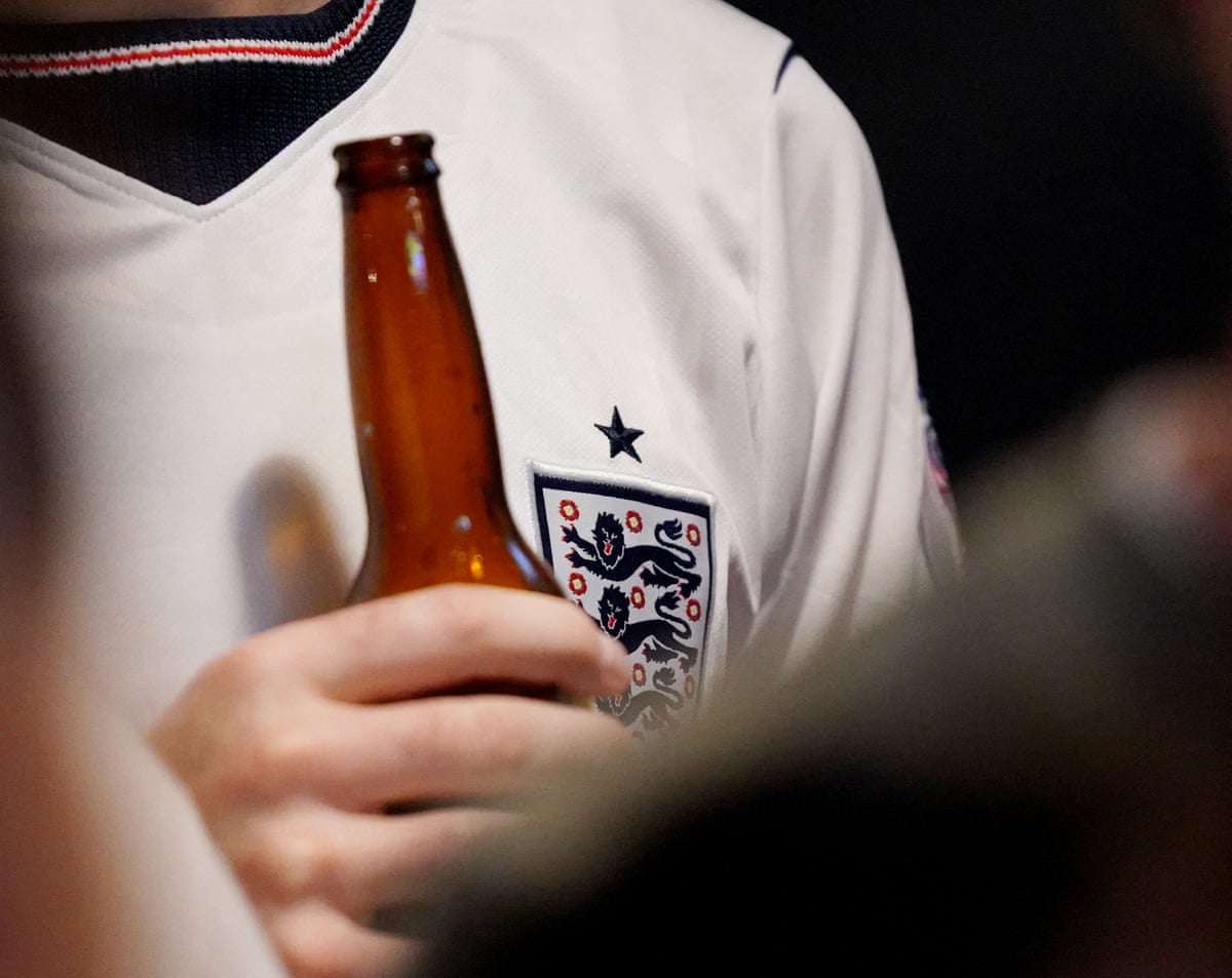 Football fan holding a beer.