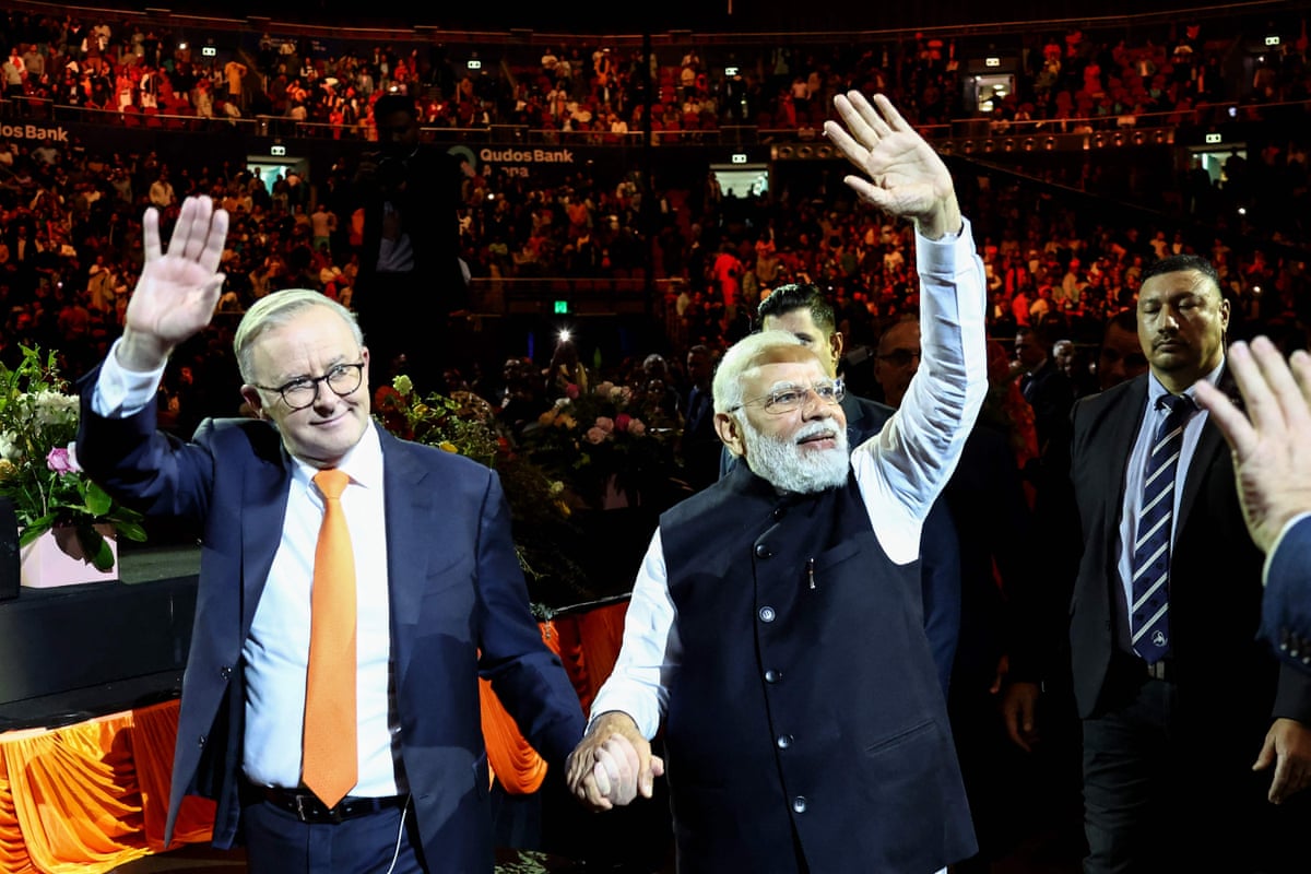 Narendra Modi (R) and Anthony Albanese wave as they leave from an event with members of the local Indian community at the Qudos Arena in Sydney