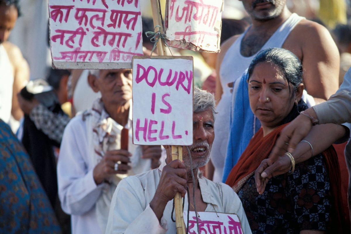 Indians protesting, with signs in a South Asian language and English, with slogans such as ‘dowry is hell’
