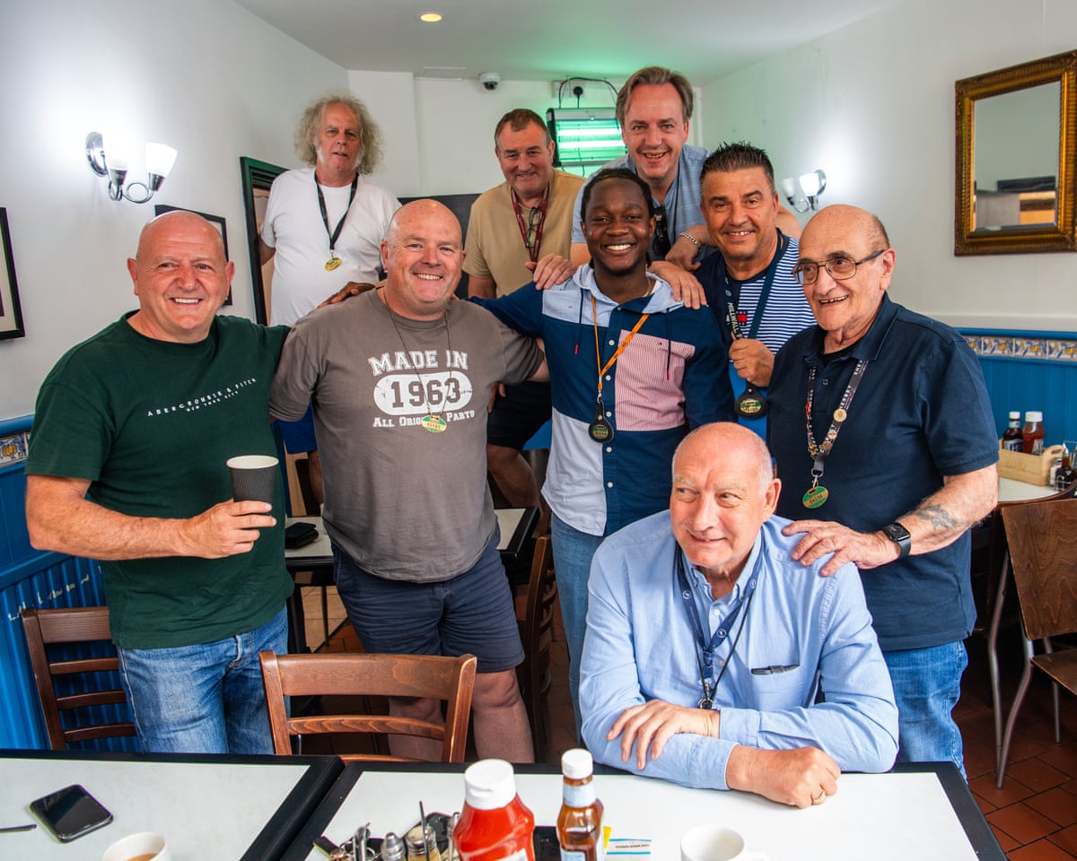 Mujagata poses for a photo with long-serving taxi drivers in a cafe