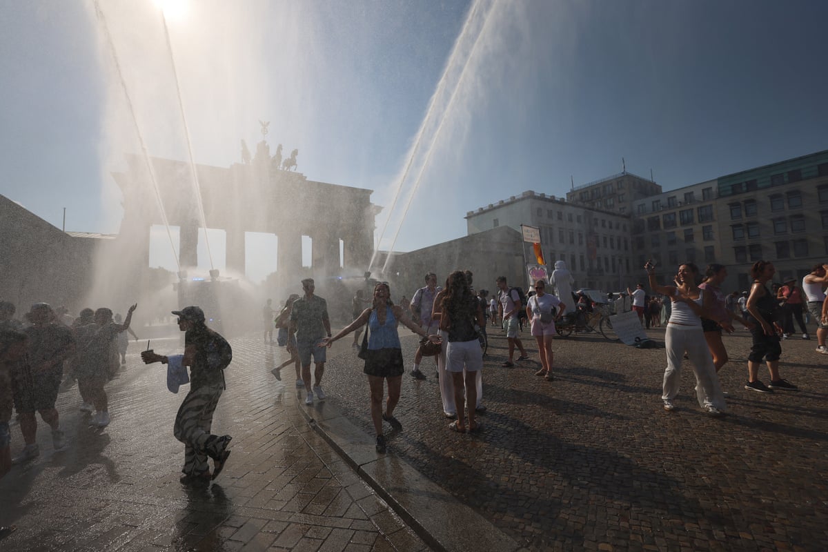 People walk among water spray near the Brandenburg Gate