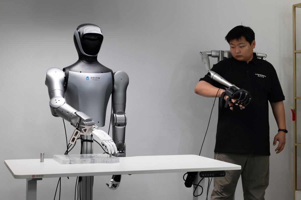 A technician demonstrates teleoperation controls on a humanoid robot