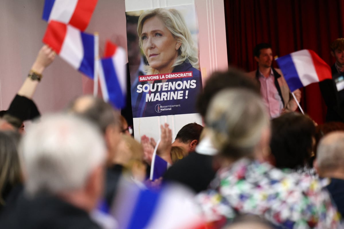People waving French flags and poster of Marine Le Pen
