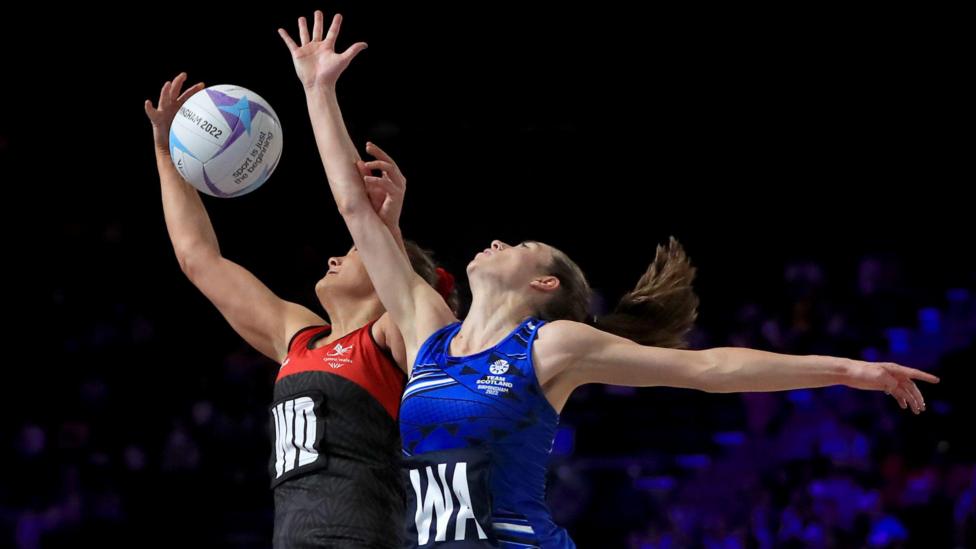 A Scotland player and Wales player compete for the ball during a netball match
