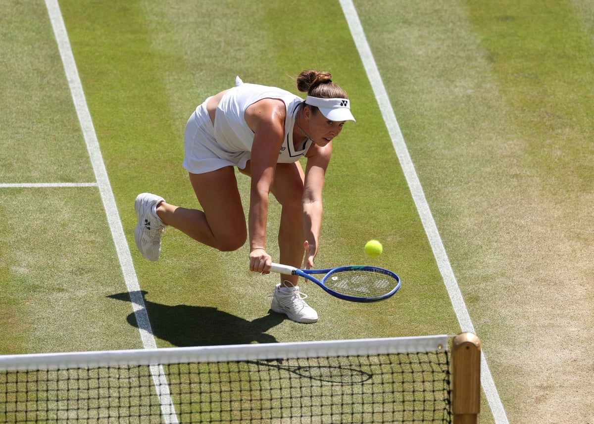 Linda Noskova plays a shot at the net against Elise Mertens