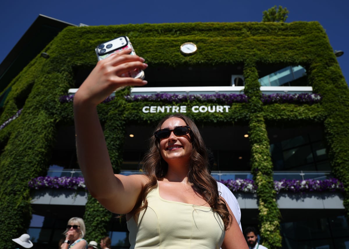 A young woman taking a selfie outside Centre Court