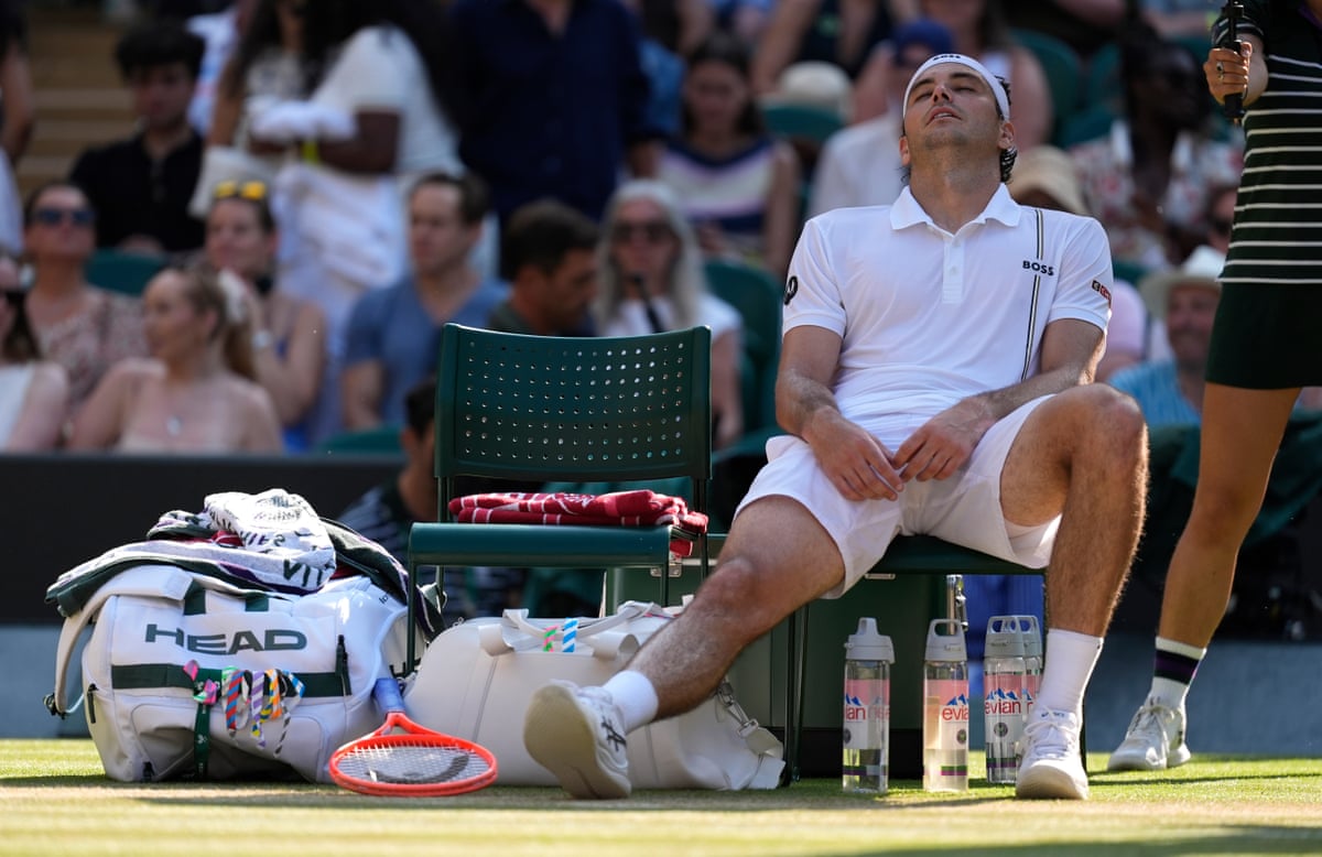 Taylor Fritz stretches out his injured knee during a change of ends.
