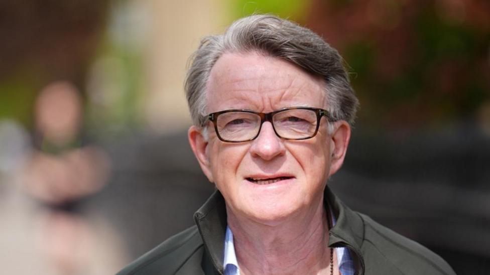 Lord Mandelson in glasses and grey jacket