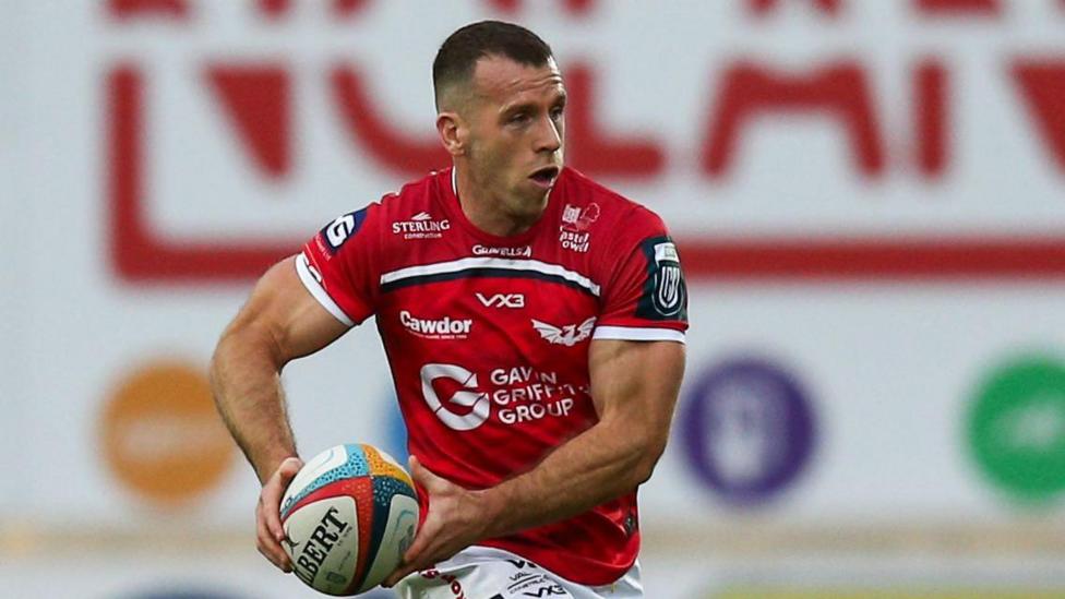 Gareth Davies runs with the ball in both hands for Scarlets
