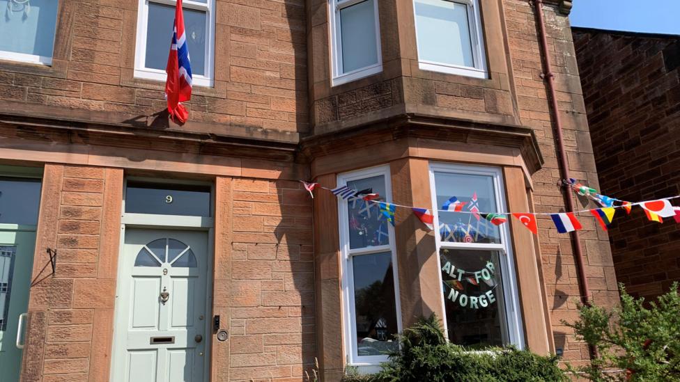 A house with a Norwegian flag above the door and the message Alt for Norge in the window