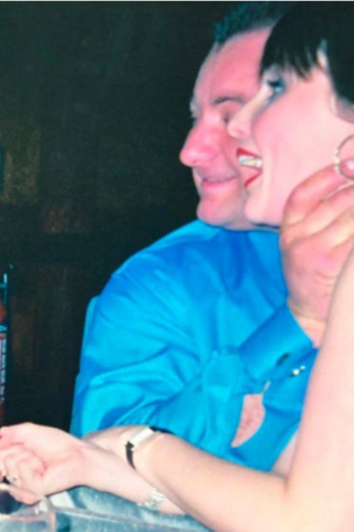 An old photograph showing a man in a blue shirt with his hand around a woman's throat. She is looking away from the camera but has a surprised expression on her face.