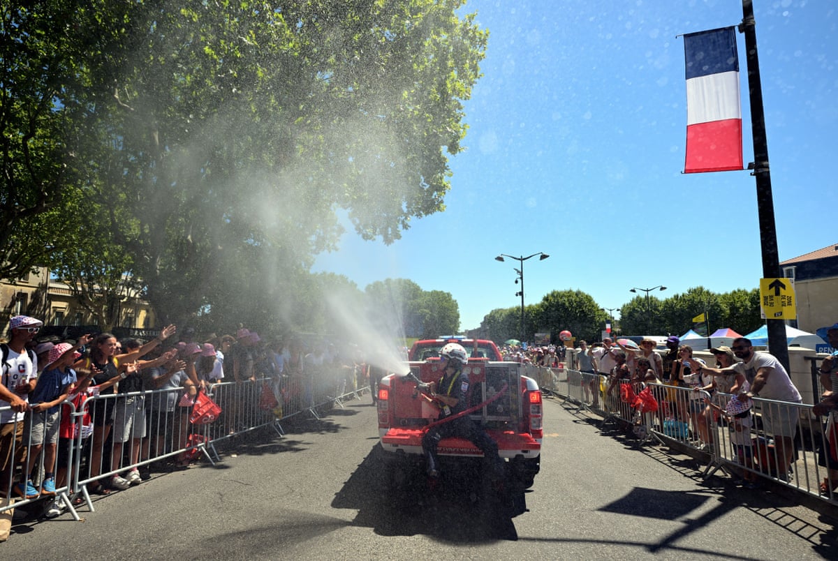 Firefighters spray the spectators with water at the start of stage four