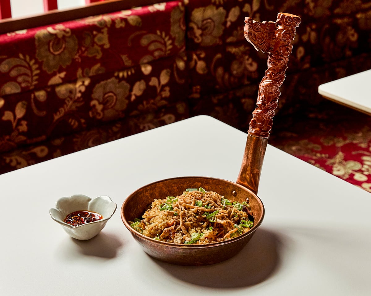 fried rice in a bowl with a very long upright carved handle