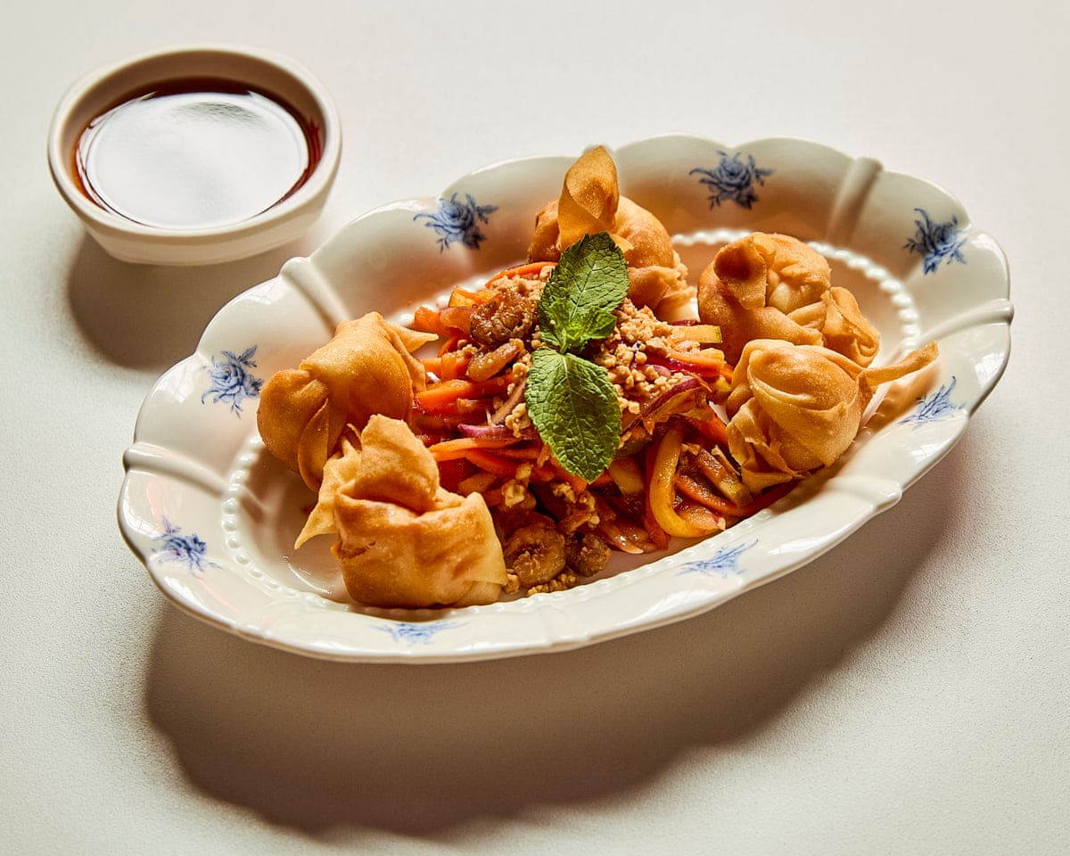 wontons on a plate with a bowl of sauce