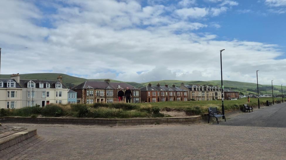 The beach and promenade at Girvan, with row of houses and B n Bs visible in the distance.